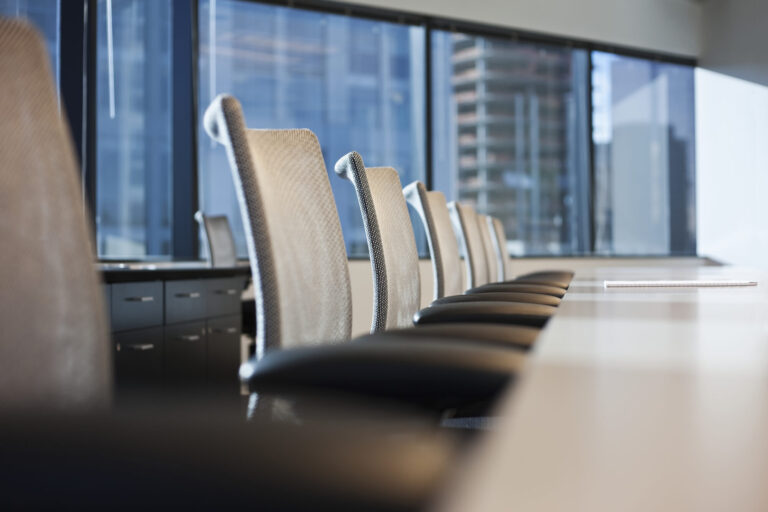 Anthropic IPO: empty boardroom chairs facing a city skyline