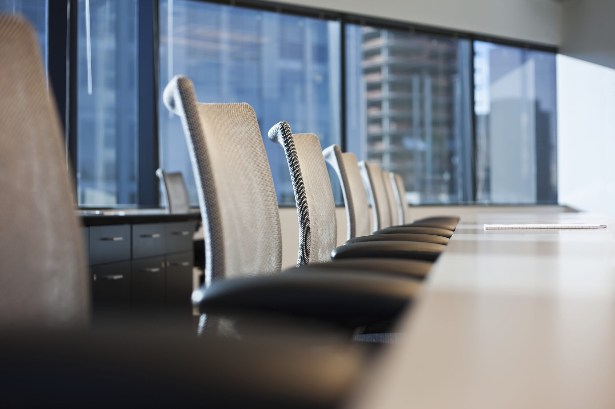 Anthropic IPO: empty boardroom chairs facing a city skyline