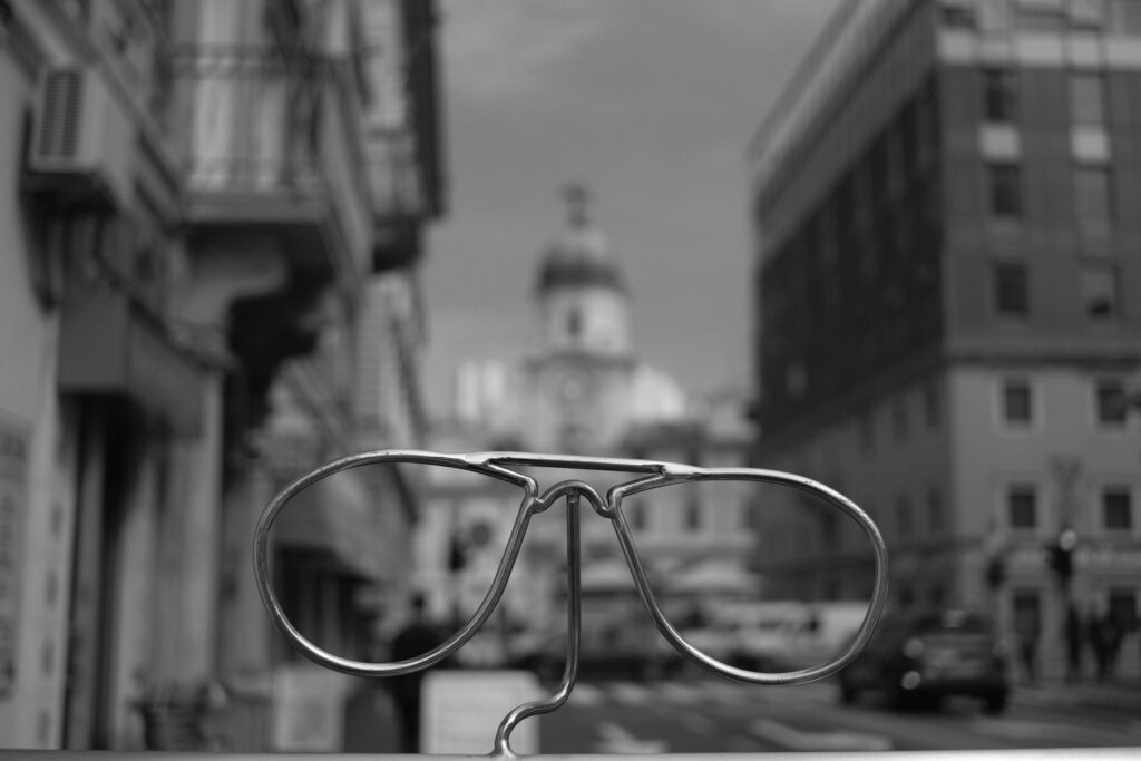 Eyeglasses frame in sharp focus against a blurred city street, illustrating how a mind-set shapes perception and cognitive bias