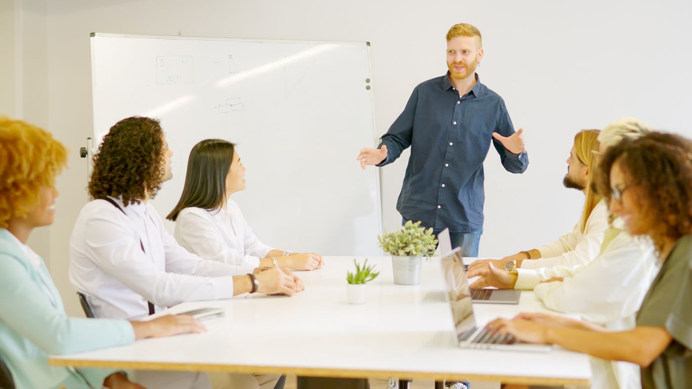 A facilitator presenting to a small group of professionals, communicating foresight in a workshop