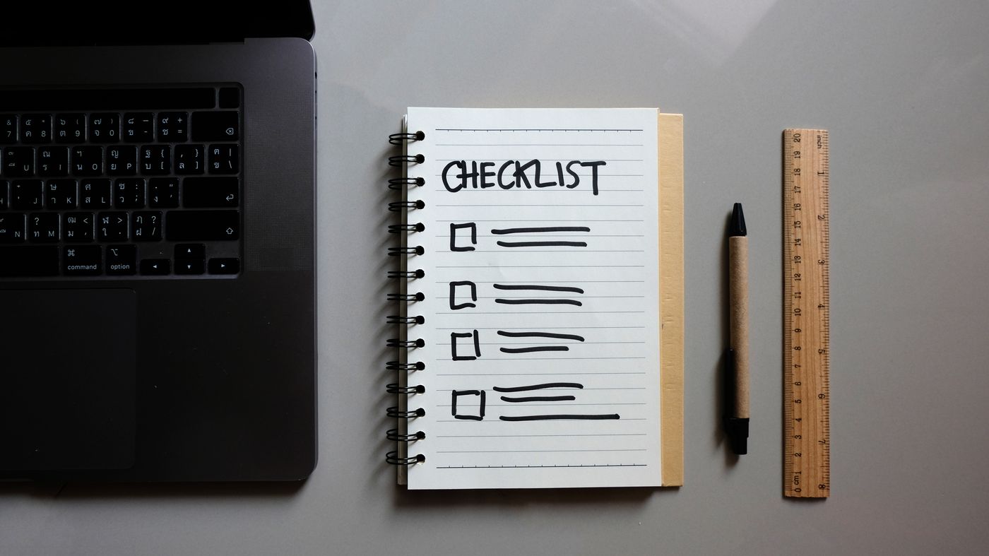 Checklist notebook beside a laptop: a forecast evaluation checklist for keeping score