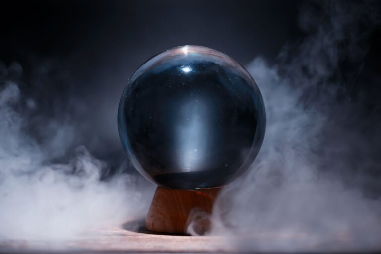 Crystal ball on a wooden stand surrounded by smoke, symbol of how hard the future is to predict